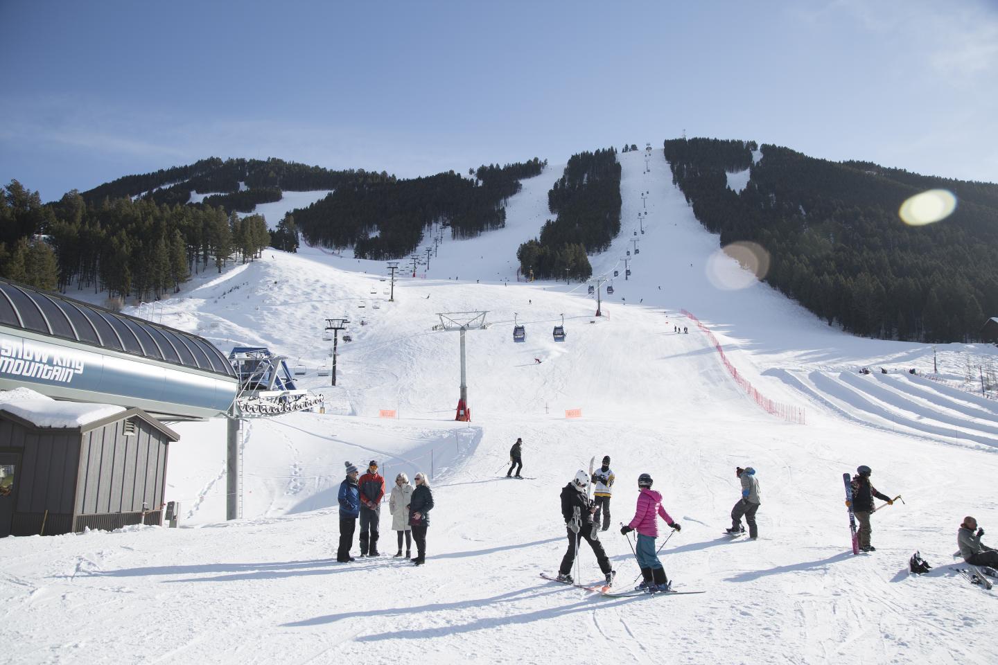 Snow King Mountain in USA - a group of people skiing down a mountain.