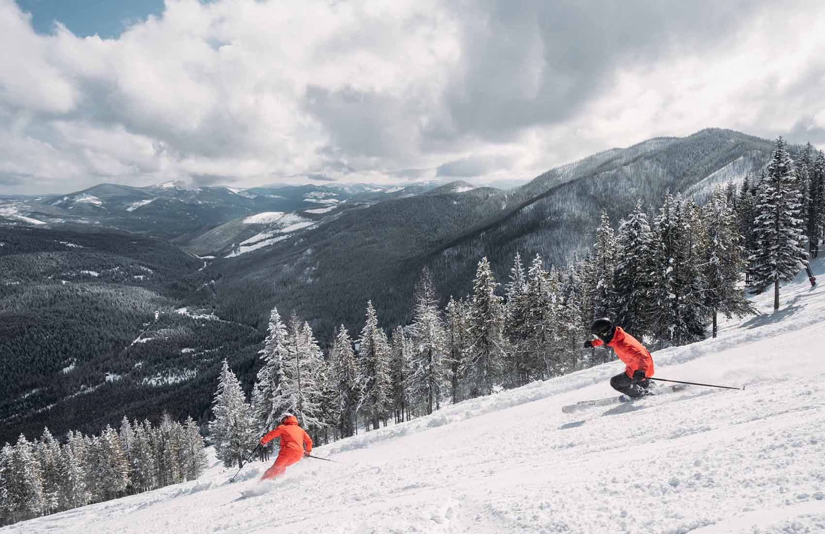 Turner Mountain in USA - two people skiing down a snowy slope in the mountains.