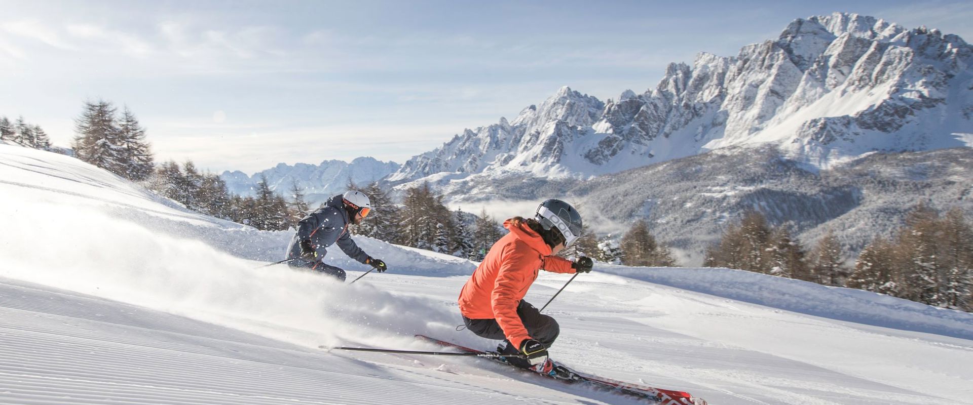 Klausberg – Skiworld Ahrntal in Italy - two people skiing down a snowy slope in the mountains.
