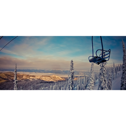 Enjoying winter sports at Blacktail Mountain ski resort in Montana with a ski lift navigating the snowy slopes against a breathtaking winter landscape. A skier is on the move adding exhilaration to the scene.