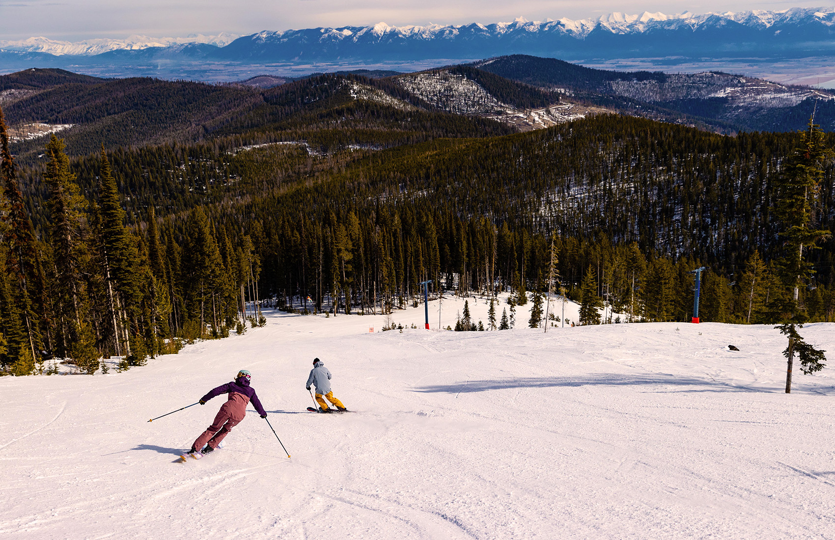 Blacktail Mountain in USA - a couple of people skiing down a mountain.