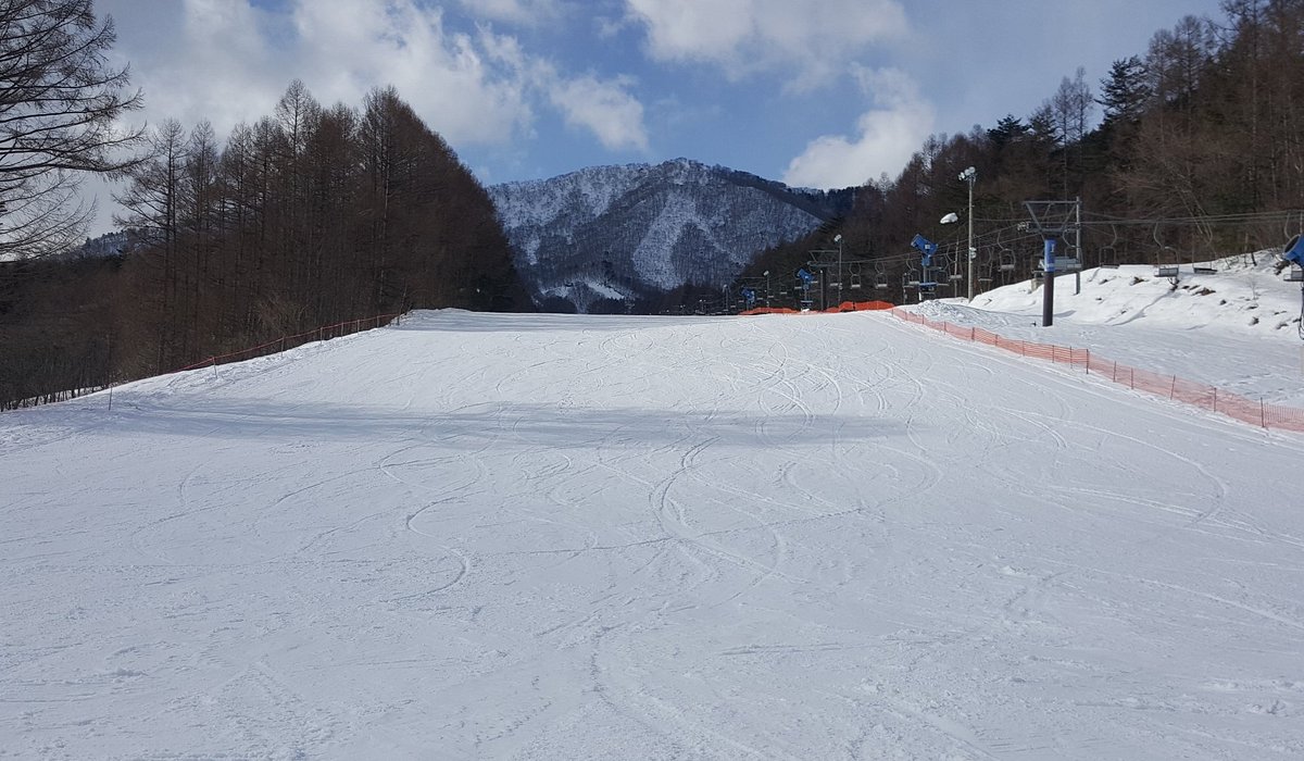 X-JAM Takaifuji in Japan - a ski slope covered in snow with mountains in the background.