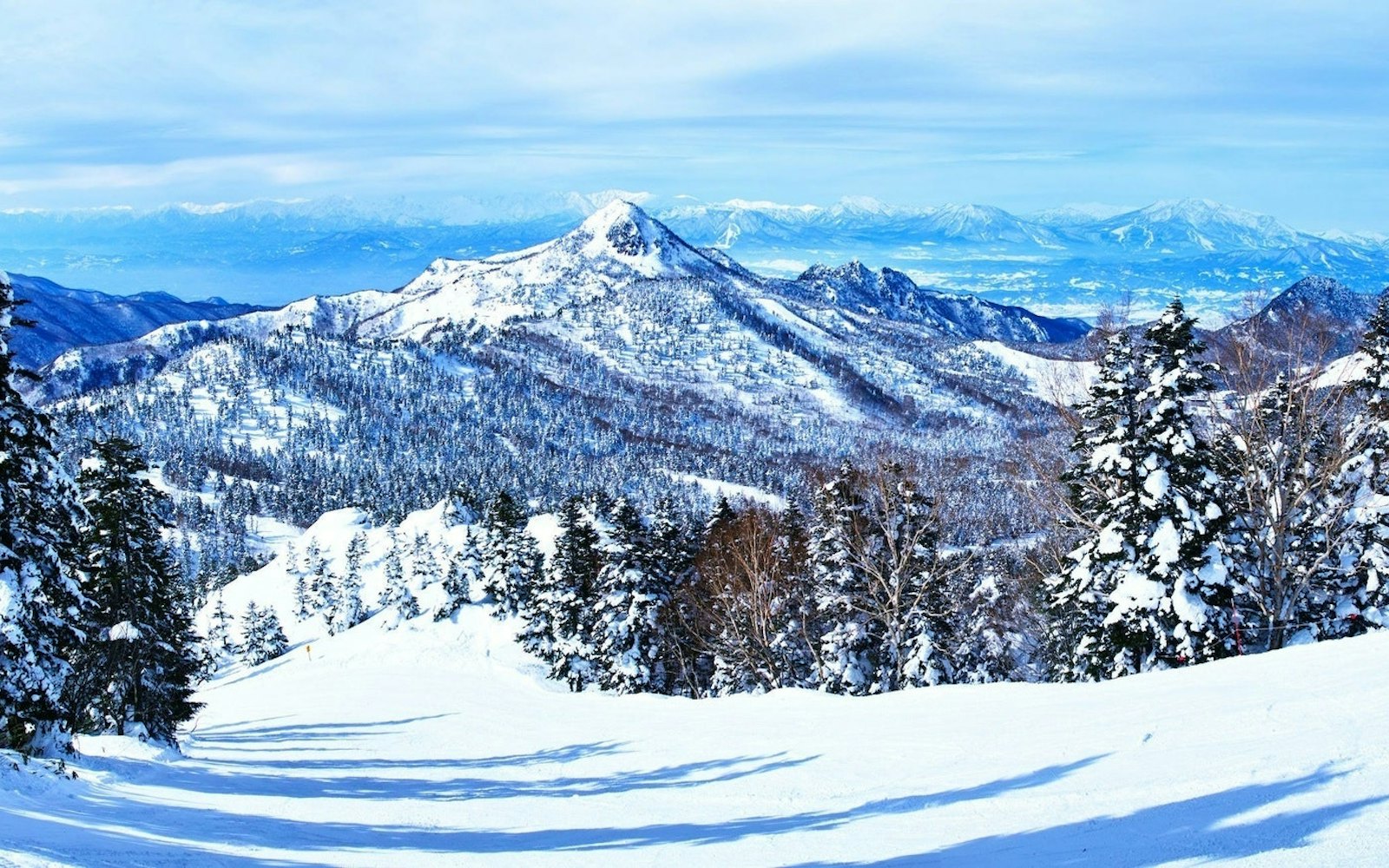 Shiga Kogen Higashitateyama in Japan - a view of the mountains from the top of a mountain.