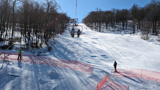 Image depicting a busy winter sports scene at Blue Knob ski resort in Claysburg Pennsylvania featuring a ski lift skiers on the slope