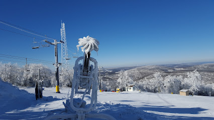 Stunning winter scene at Blue Knob in Pennsylvania featuring a ski resort with active ski lift and a skier navigating the snowy terrain.
