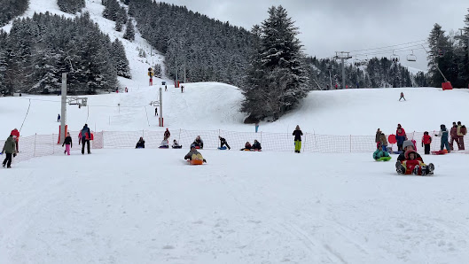 Winter sports scene at Mourtis in Haute-Garonne, France, featuring skiers at a ski resort. A charming chalet can be seen amidst the snowy landscape.