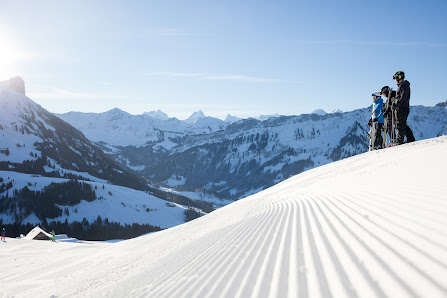 A skier in action at Sportbahnen Marbachegg, Lucerne, Switzerland. The lively winter sports scene unfolds amidst snow-covered slopes, with a picturesque ski resort and challet in the backdrop.