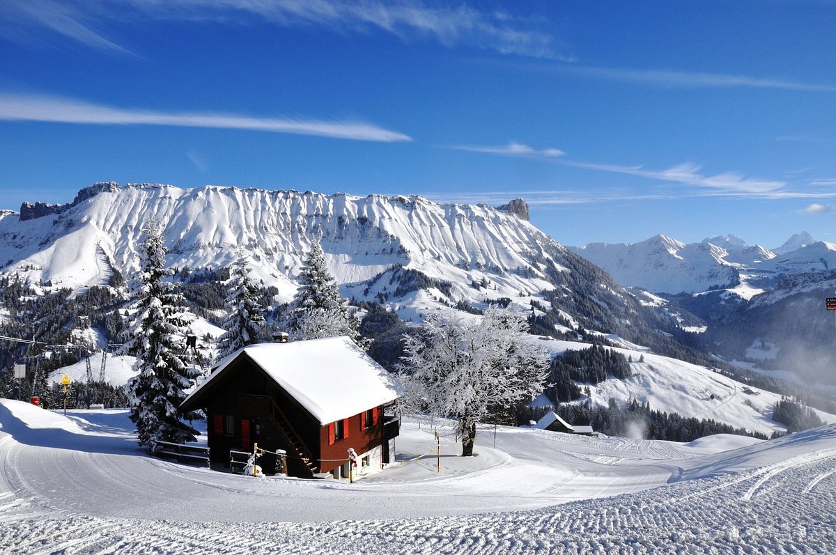 Sportbahnen Marbachegg in Switzerland - a cabin in the snow with mountains in the background.
