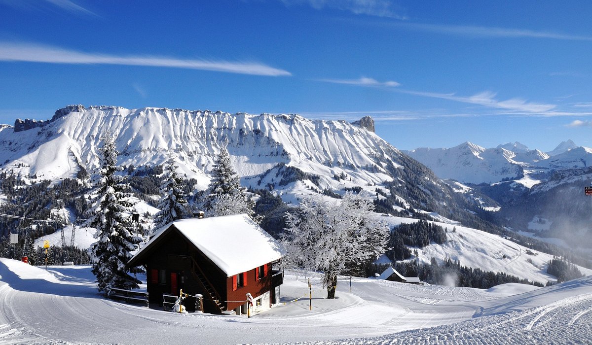 Sportbahnen Marbachegg in Switzerland - a red cabin in the snow with mountains in the background.