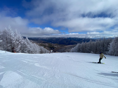 A skier gliding down a slope at Yabuhara Kogen a ski resort in Chūbu Japan against a breathtaking winter backdrop