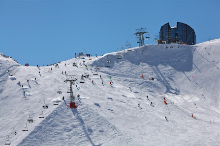 View of the Les Mosses - La Lécherette ski resort in Switzerland featuring a winter sports scene with a ski lift and a charming challet amid snow-capped Swiss Alps.