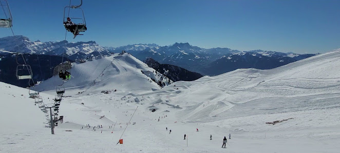 Scenic view of a challet in Les Mosses - La Lécherette, Switzerland. The image features a ski resort and winter sports activity with a skier on the snow-covered slopes, encapsulating the spirit of Swiss winter sport.