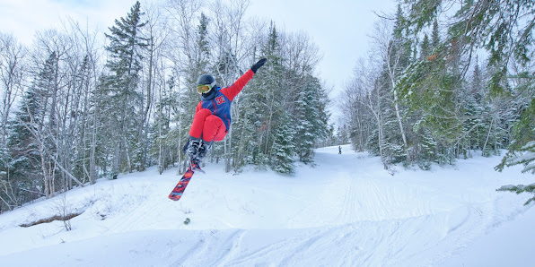 A skier gliding down a snowy slope at Mont Béchervaise in Gaspé Quebec Canada embodying the energy of winter sports