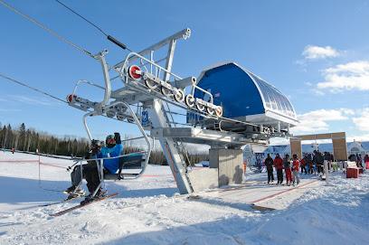 A ski lift stands out in the snowy landscape of Mont Béchervaise in Quebec indicating a lively ski resort and winter sports centre. The scene encapsulates the thrill of winter sports.