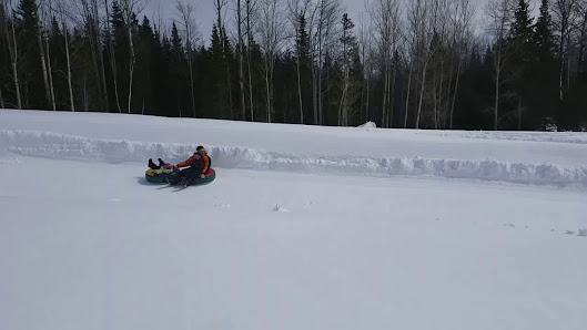 Snowmobile in action at Mont Béchervaise in Gaspésie Quebec displaying winter sports activities and facilities in a snowy Canadian landscape.