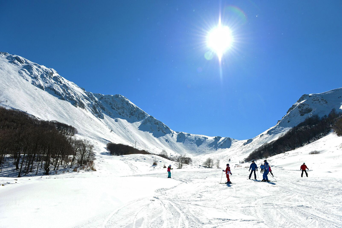 Campo Stella – Leonessa in Italy - a group of people skiing down a snowy slope.