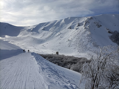 Winter scene at Campo Stella – Leonessa in Italy, showcasing a bustling ski resort amid stunning winter scenery, complete with a cozy chalet amidst snow-covered surroundings.