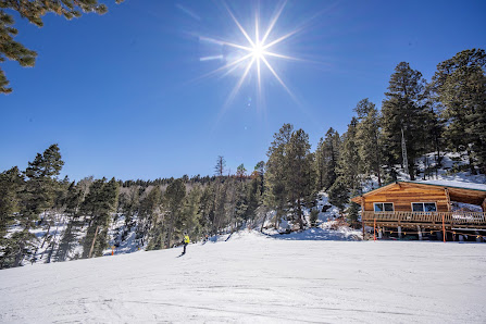 Sipapu Ski Resort in Vadito, New Mexico, teeming with sports enthusiasts amidst stunning winter scenery. Ski lift lines course against the pristine white backdrop of snowy slopes.