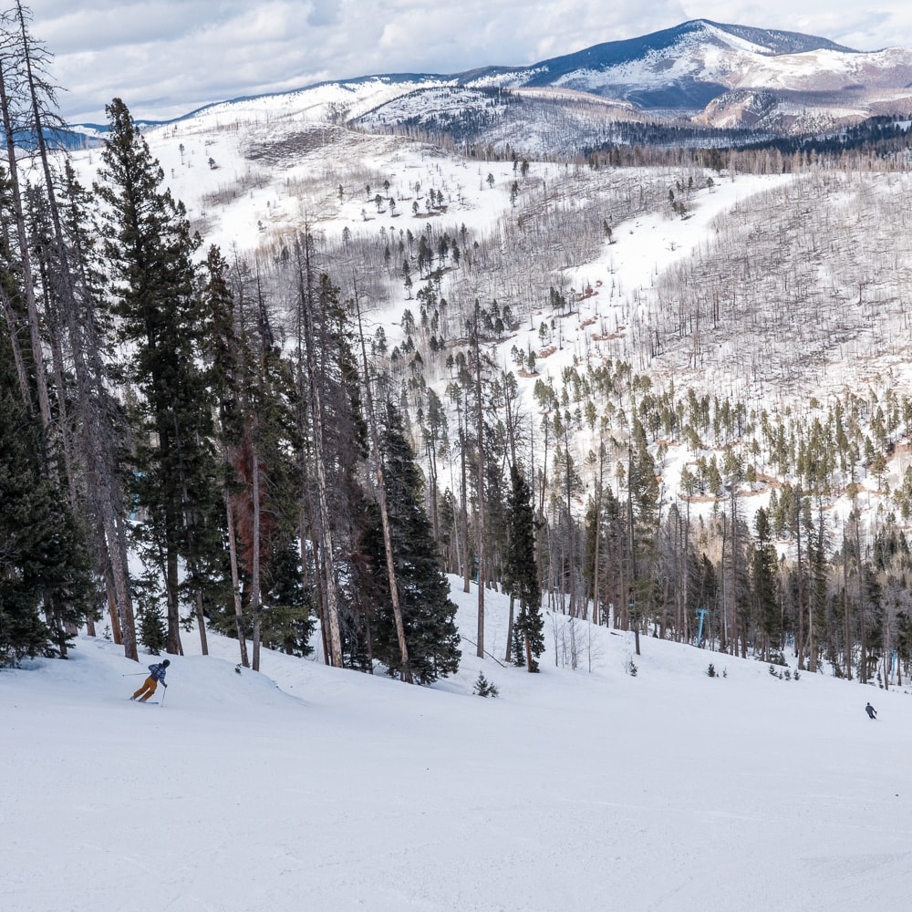 Sipapu in USA - a person is skiing down a snowy slope.