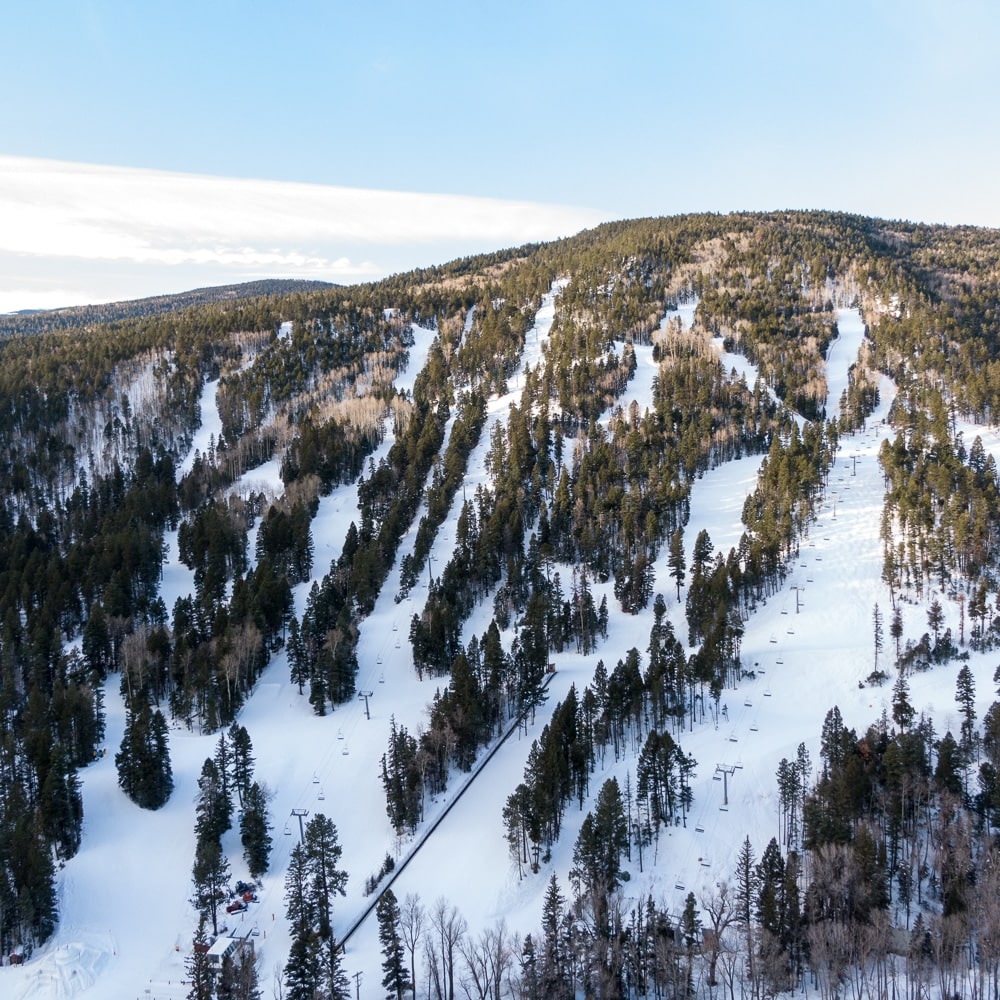 Sipapu in USA - a ski slope with trees and snow on it.