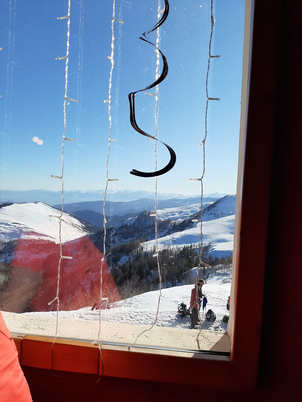 Pian Munè – Paesana in Italy - a person looking out a window on a snowy mountain.