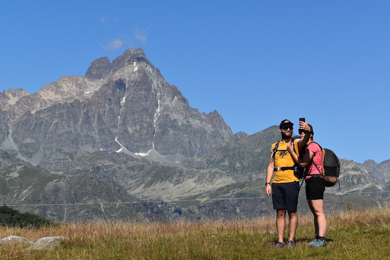 Pian Munè – Paesana in Italy - a woman standing on top of a grass covered hill.