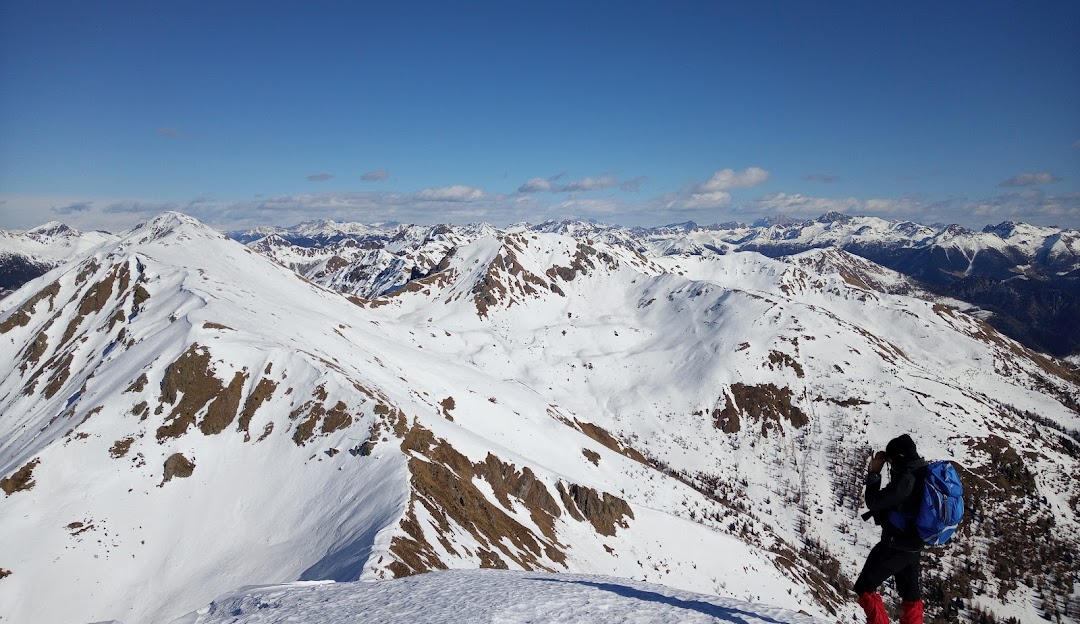A chalet nestled in Panarotta 2002, Trentino, Italy, on the backdrop of a majestic mountain. The area bustling with winter sports activities, particularly skiing at the resort.
