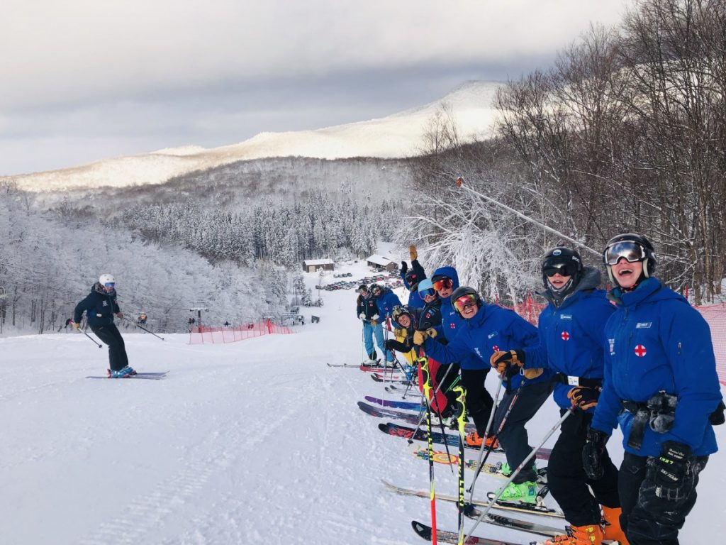 A picturesque winter scene at Middlebury Snowbowl in Hancock Vermont featuring a group of people and a family enjoying skiing activities at the lively ski resort.