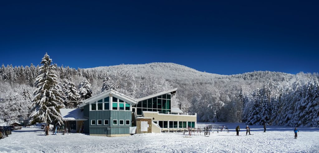 View of Middlebury Snowbowl, a bustling winter sports centre in Vermont, USA, featuring pristine ski slopes amidst stunning winter scenery.