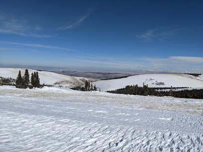 Winter scene at Pomerelle ski resort, Albion, Idaho, showing off snow-covered slopes and a quaint chalet amidst pristine, untouched snow. Ideal for winter sports enthusiasts.