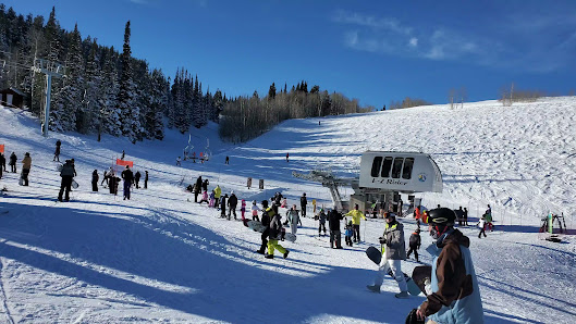 Image of Pomerelle ski resort, Albion, Idaho, featuring snow-covered slopes dotted with ski lifts, in a bustling winter sports scene.
