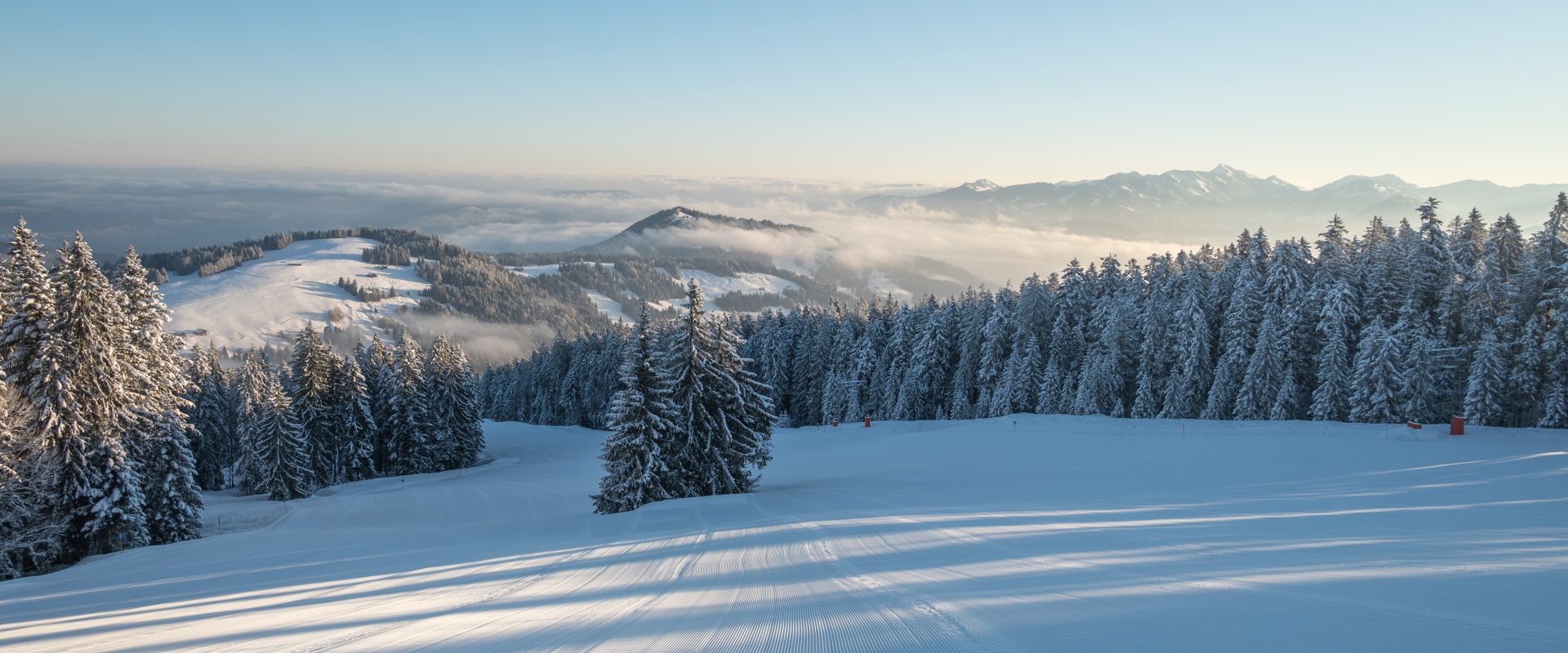Bödele in Austria - a snowy landscape with trees and snow covered mountains.