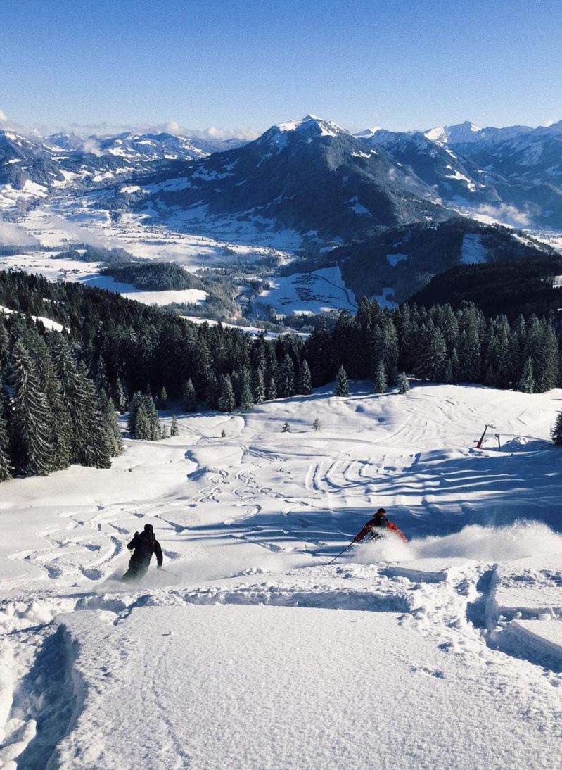 Bödele in Austria - a person skiing down a snowy slope in the mountains.