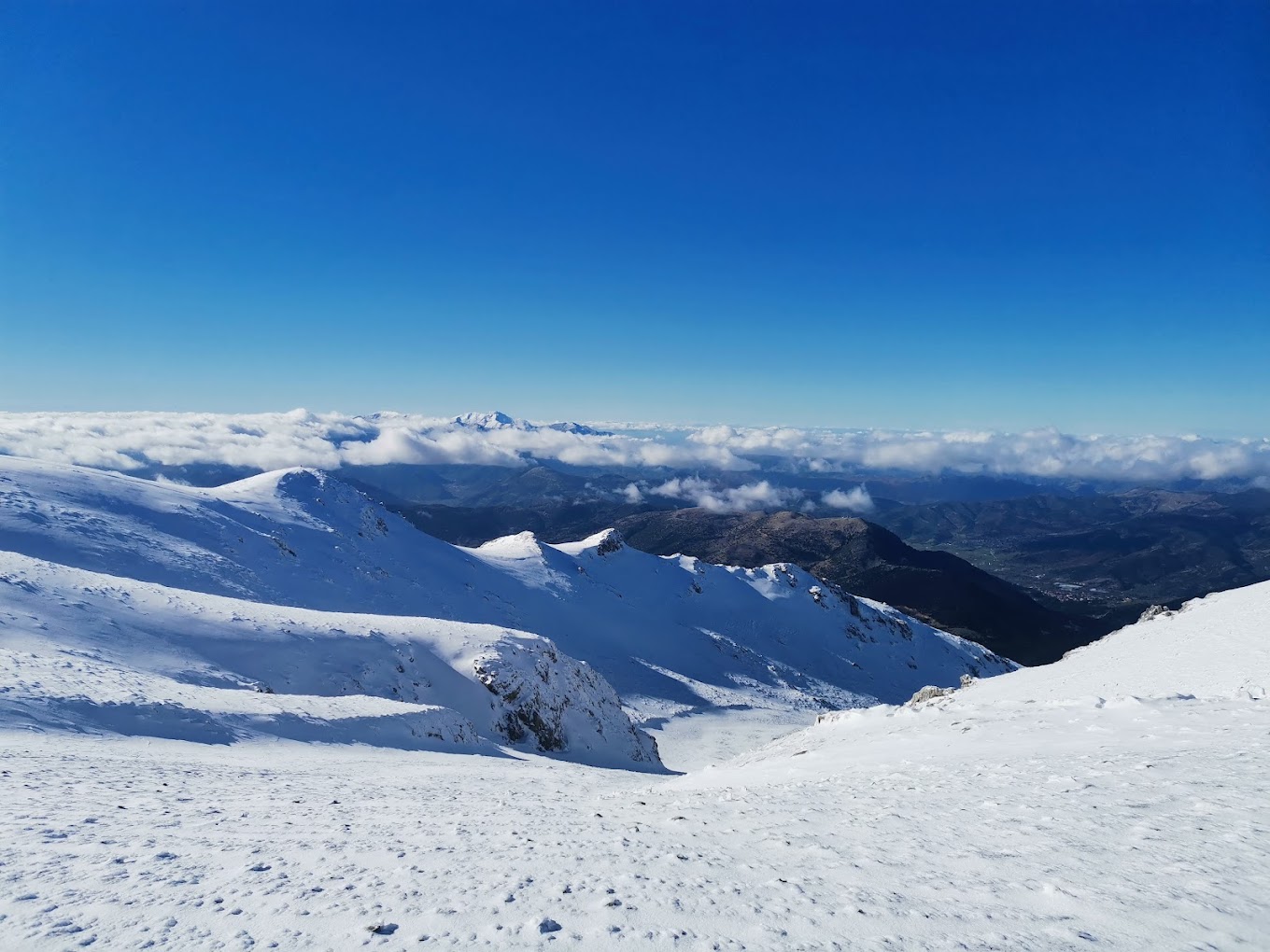 Skiers enjoying winter sports at the Ski Center in Chelmos, Kalavrita, Greece, with a charming chalet and the stunning, snow-covered mountainous backdrop.