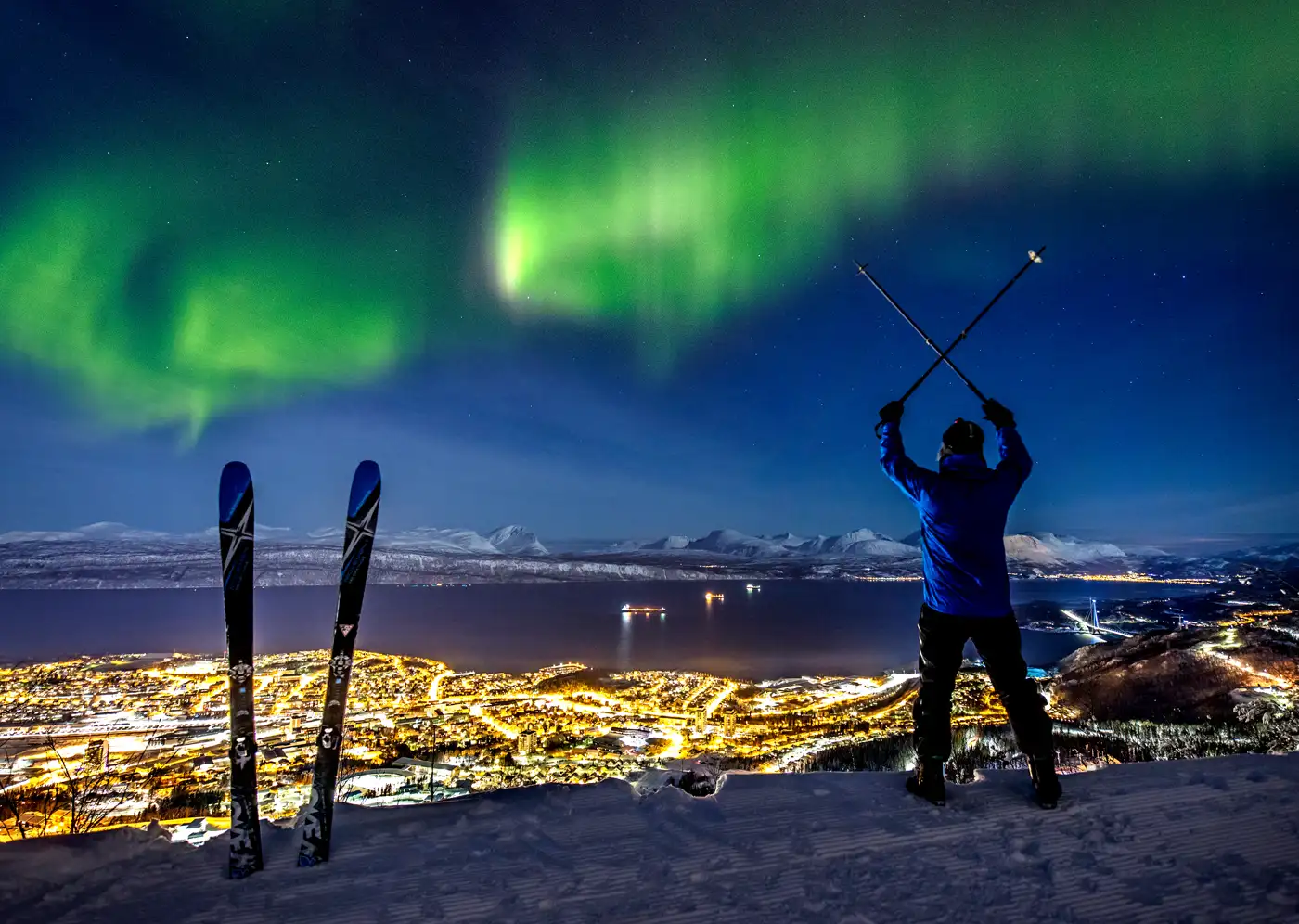 Sjusjøen in Norway - a man holding skis and looking at the northern lights.