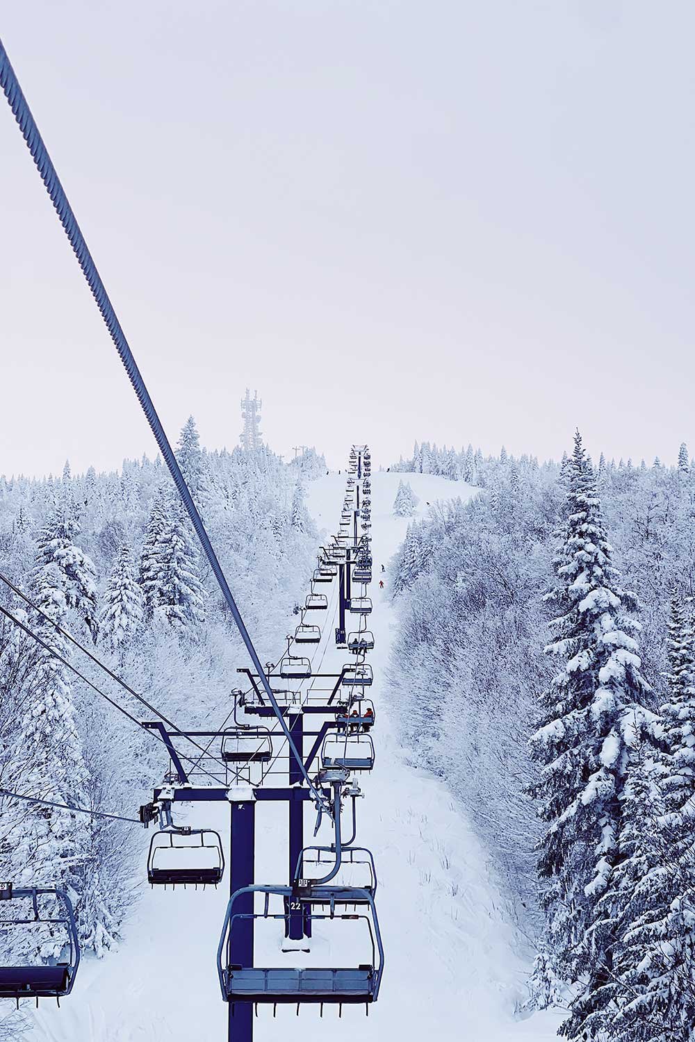 Mont-Tremblant in Canada - a ski lift going up a snowy hill.