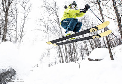 A snowboarder carving down the pristine slopes of Sommet Morin Heights in Laurentides, Quebec, Canada. The snow is perfectly groomed providing optimal conditions for winter sports.