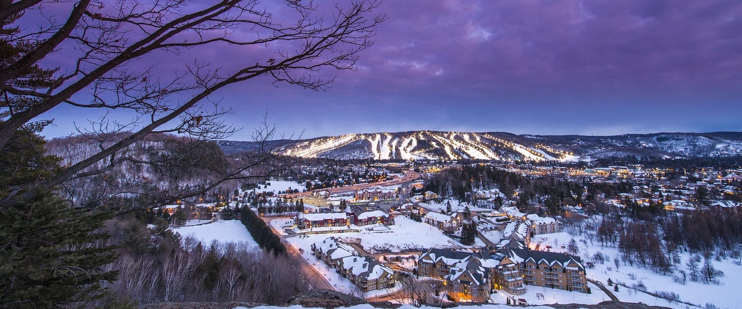Sommet Morin Heights in Canada - a view of a town in the mountains at dusk.