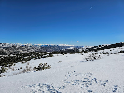 Winter sports enthusiasts enjoy activities at L'Audibergue - La Moulière in France, with a charming chalet nestled amidst a stunning, snow-covered landscape.