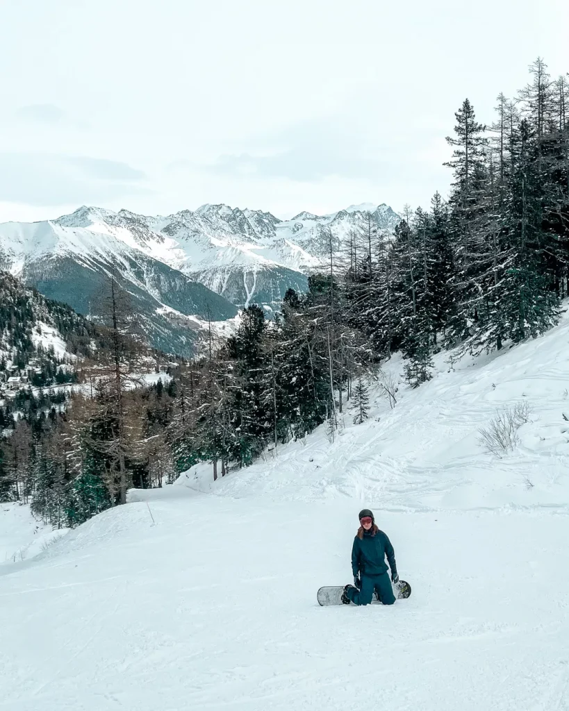 Champex-Lac in Switzerland - a person sitting in the snow on a snowboard.