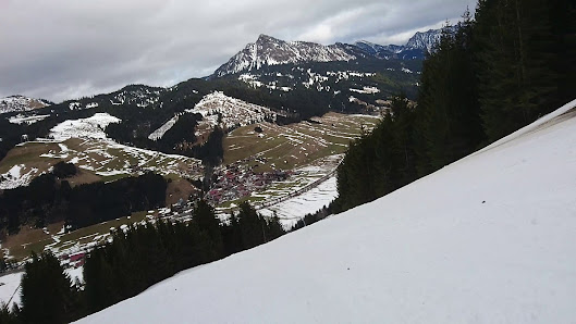 A charming chalet situated in the scenic ski resort of Schattwald - Zöblen in Tyrol, Austria. Winter sports enthusiasts are seen enjoying the pristine slopes, with the majestic mountains as a backdrop.