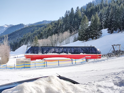 Skiing scene at the Schattwald - Zöblen winter sports centre in Tyrol, Austria, featuring a ski resort with a chalet and ski lift amid snowy landscape.