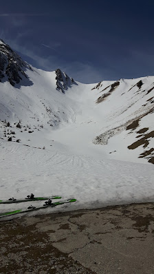A skier in action at the Schattwald - Zöblen ski resort in Tyrol, Austria, with a charming chalet and striking mountain in the backdrop, creating a classic winter sports scene.