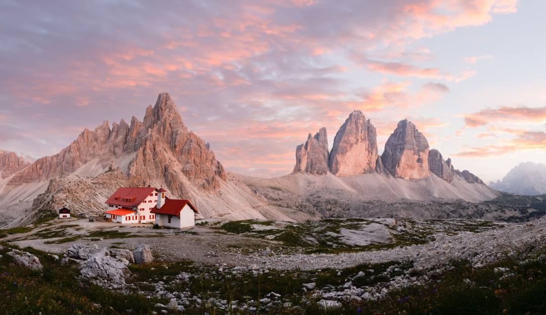 Three Peaks Dolomites in Italy - a house in the mountains at sunset.