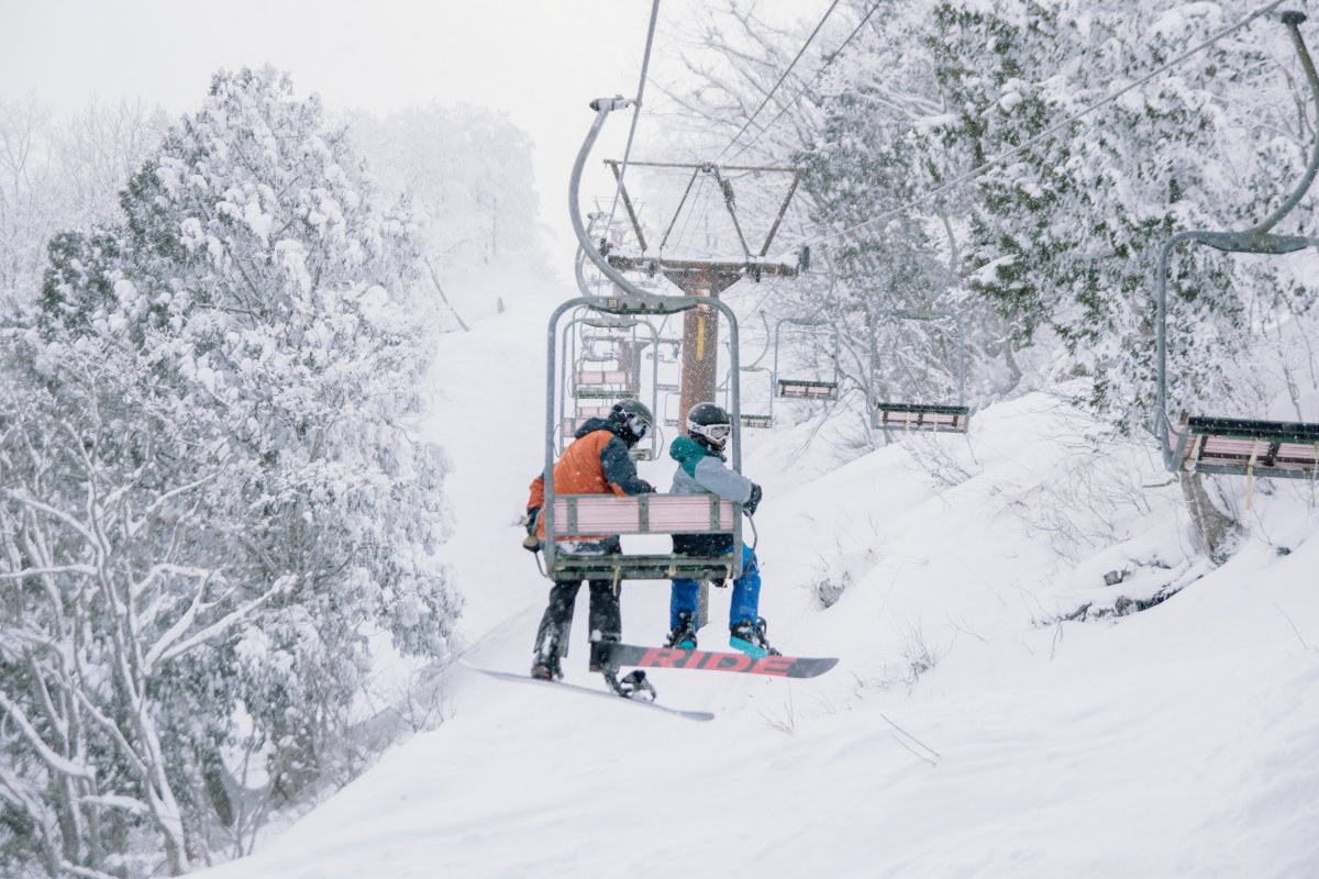 Kurobushi Kogen Snow Park Jangle Jungle in Japan - a person riding a ski lift in the snow.