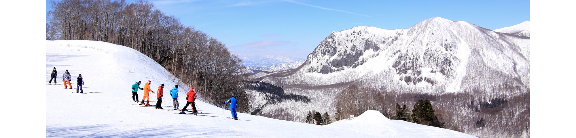 Kurobushi Kogen Snow Park Jangle Jungle in Japan - a group of people skiing down a mountain.
