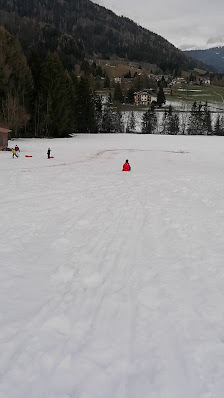 Skiers enjoying winter sports at a ski resort on the slopes of Monte Altissimo in Borno Italy including a child learning to ski.