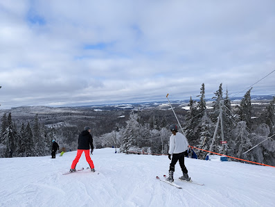 Winter scene at Poley Mountain ski resort in Waterford, New Brunswick, Canada featuring a ski lift and skiers enjoying the slopes.