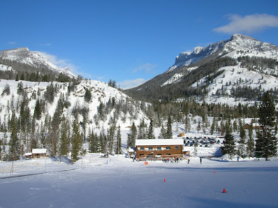 A picturesque view of the Sleeping Giant ski resort in Cody Wyoming featuring its winter sports center amidst pristine winter scenery.