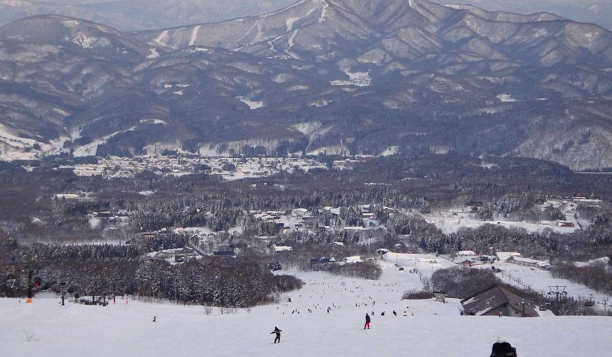 Ikenotaira Onsen in Japan - a group of people skiing down a snow covered mountain.